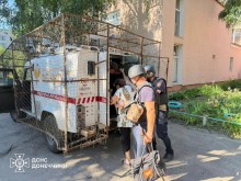 Рятувальники групи "Фенікс" допомагають жінці сісти в евакомобіль