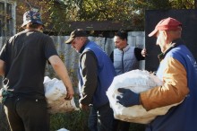 Волонтери допомагають людям вантажити твердопаливні брикети