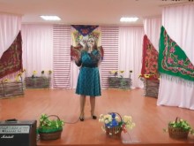 Учасниця конкурсу виконує пісню на сцені, прикрашеній рушниками