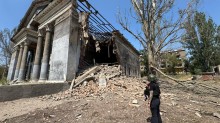 Правоохоронець дивиться на зруйнований палац культури.
