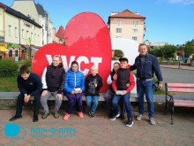 Спільне фото. Діти та дорослі біля надпису "Я люблю Хуст". Велике червоне серце на задньому плані.