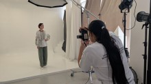 Фотографиня знімає модель у вишитій сорочці та зелених штанах