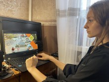 Дівчина за ноутбуком перегдядає відеоролик про Бахмут.