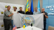 Учасники зустрічі тримають в руках прапор