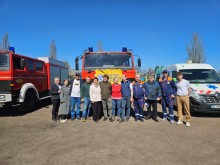 Передача гуманітарної допомоги у вигляді спеціалізованого транспорту. На передньому плані стоять представники міжнародних організацій та області.