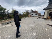 Правоохоронець стоїть на території поруч зі зруйнованим окупантами храмом