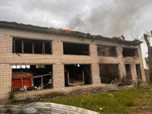 Адміністративна будівля, в якої вилетіли вікна та горить покрівля, через обстріли окупантів.