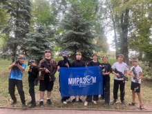 Учасники гри "Лазертаг" зі спорядженням тримають прапор Центру ВПО "Миразом"