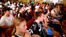 Діти в глядацькій залі уважно дивляться виставу, сидячи у кріслах