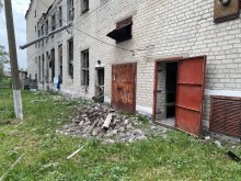 Пошкоджена через обстріл окупантів адміністративна будівля, біля якої лежить цегла.