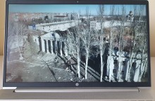 На екрані телевізора фотографія повністю знищеного обстрілами Росії театру