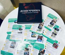 На столі лежить по центру книга про Донеччину, поруч буклети.