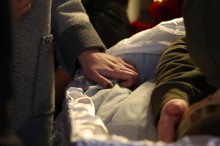 Рука, яка тримається за труну на похороні