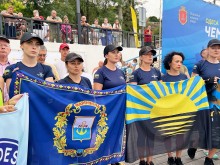 Команда поліціянток з Донеччини тримає прапори Донецької області та Маріуполя