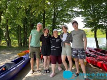 Молоді люди обіймаються на фоні річці біля байдарок