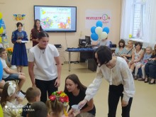 Урочистий захід до Дня знань у приміщенні освітньої локації Курахівської ТГ м. Дніпро: випускники вітають першокласників. Навколо — кульки, глядачі та святкова атмосфера.
