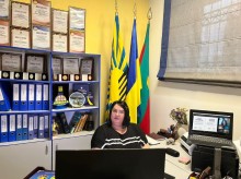 Фахівець військової адміністрації сидить за столом слухаючи питання, які виствітлюються на семінарі