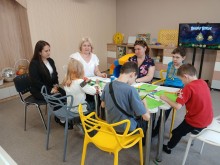 Діти виконують творчі завдання за круглим столом столом під керівництвом педагогів у Центрі інклюзивного навчання.