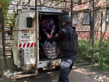 Рятувальники допомагають літній жінці сісти в евакуаційний автомобіль