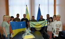 Дві громади, спільне фото. Попереду тримають прапори України та Донеччини. На столі лежить пиріг Незалежності від Очеретинської громади.