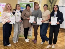 Шестеро жінок-педагогів Добропільської громади стоять у приміщенні після завершення тренінгу, тримаючи сертифікати про участь.