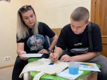 Хлопчик разом з мамою розмальовує шопер