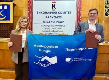 Заступниця начальника Новогродівської МВА Ольга Сидорова та міський голова Калуша Андрій Найда тримають прапор про партнерство обох громад