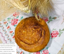 Кругла паляниця на рушнику, поруч колосся пшениці