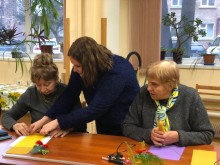 Музейники допомагають гостям робити свічки