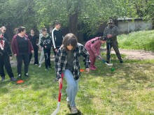 Група підлітків та дорослих разом з ветераном грають у спортивні ігри на галявині