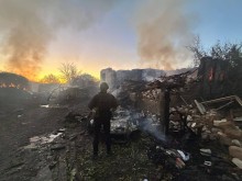 Правоохоронець стоїть біля зруйнованого ворожим обстрілом будинку
