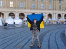 Представник театру тримає на витягнутих руках наш стяг на фоні Колізею