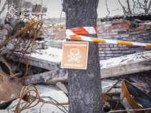 Попереджувальна табличка, де на червоному фоні напис "Небезпечно міни".