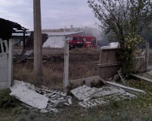 Зруйновані будівля тушить пожежна машина