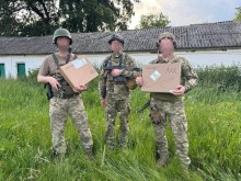 Троє військових у формі тримають коробки Starlink, отримані від Маріупольського коледжу.