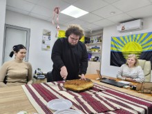 Чоловік розрізає василопіту - традиційний новорічний обряд надазовських греків