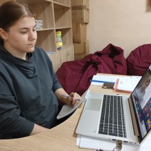 Фахівець військової адміністрації сидить за столом та слухає доповідачів, котрі висвітлюють актуальні питання на семінарі