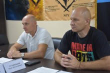 Учасники робочої групи «Прозорість і підзвітність» уважно слухають. Позаду них прапори військових частин.