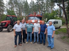 Представники парку "Святі Гори" позують на фоні техніки: пожежного автомобіля, трактора та бусіка