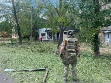 Правоохоронець стоїть біля крамниці, зруйнованої ворогом.
