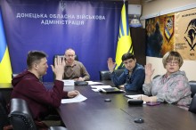 Учасники засідання комісії з визначення підприємств, установ і організацій, які є критично важливими голосують за столом