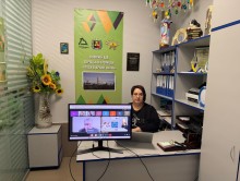 Представник військової адміністрації сидить за столом та слухає доповідача на семінарі