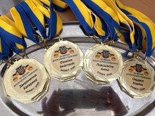Іменні медалі з написом «За високі досягнення у навчанні» для випускників Бахмутської громади 2025 року, прикрашені стрічками у кольорах державного прапора.