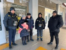 Сімейна пара похилого віку разом з рятувальниками біля евакопункту