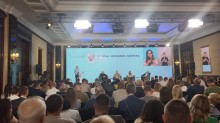 Групове фото, зроблене у великій залі. Близько ста людей стоять рядами, дивлячись у камеру. За ними розташований великий екран з написом "Україна. Ветерани. Безпека" та гербом України.