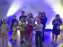 Юні відвідувачі співають з мікрофонами на музичному занятті