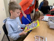 Діти читають книжки у локації «Книжкові полички» в осередку підтримки мешканців Бахмутської громади «З Бахмутом у серці» у Києві.