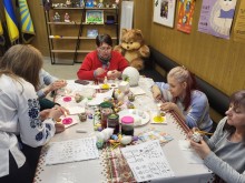 Жінки- переселенки з Донецької області власноруч створюють писанки, використовуючи традиційні інструменти та матеріали.