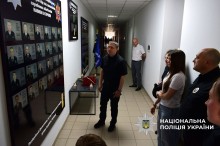 Поліцейські разом з родинами загиблих переглядають дошку пошани