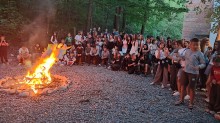 Велика група дітей біля вечірньої ватри